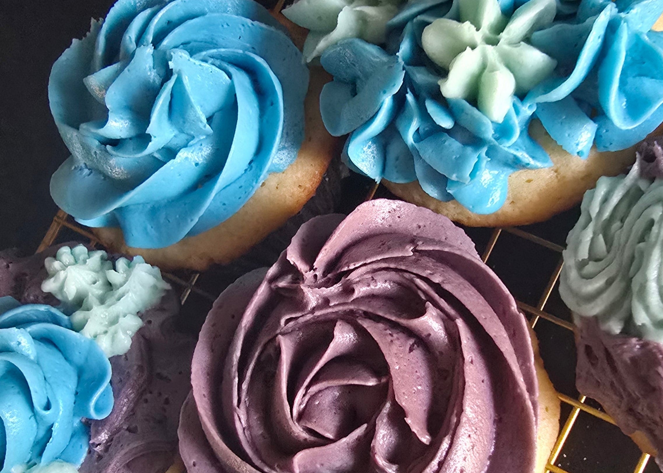 Cupcakes with colorful frosting on a cooling rack